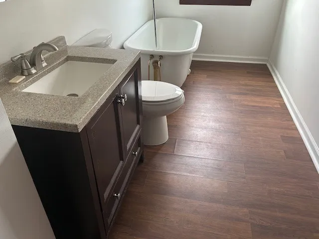 a bathroom with a granite countertop sink a toilet and a mirror