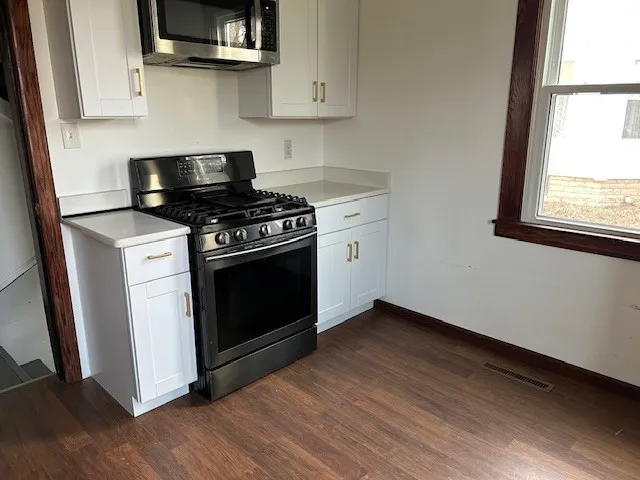 a kitchen with stainless steel appliances a stove a microwave and sink