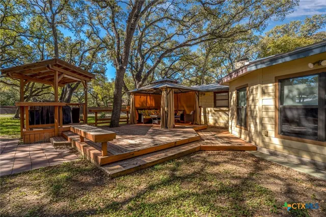 a view of a house with backyard and sitting area
