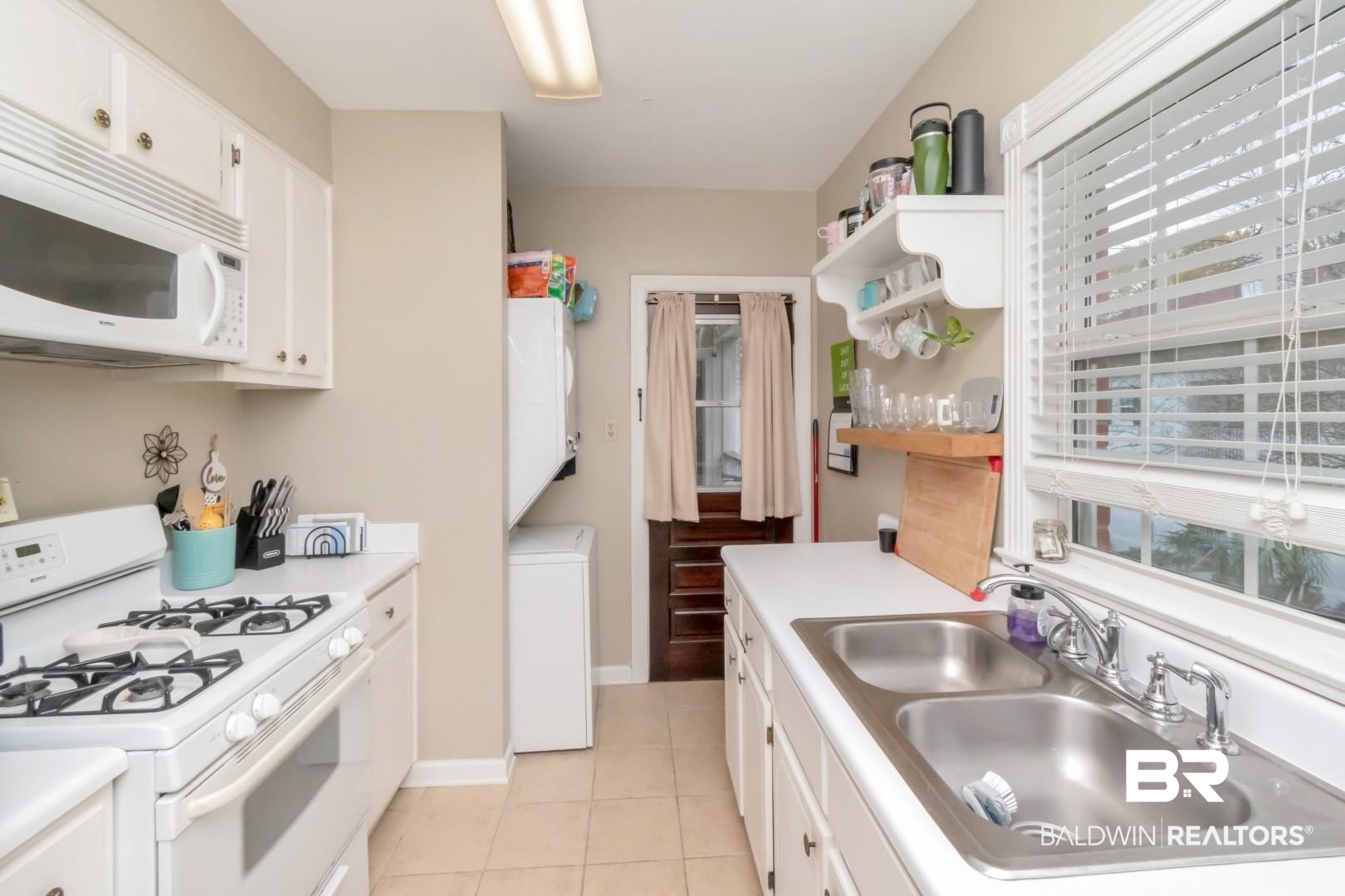 214 Upham Street, Unit 17C Mobile, AL 36607 - Photo 20 of 32 Kitchen featuring white appliances, white cabinetry, open shelves, and light countertops