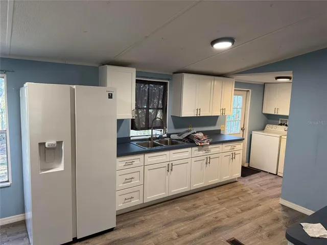 a kitchen with stainless steel appliances a refrigerator sink and cabinets