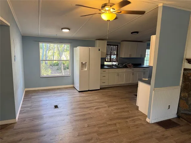 a kitchen with stainless steel appliances granite countertop a refrigerator a stove a microwave oven with wooden floor and cabinets