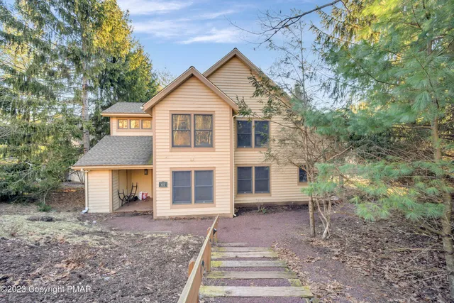 a front view of a house with a yard and trees