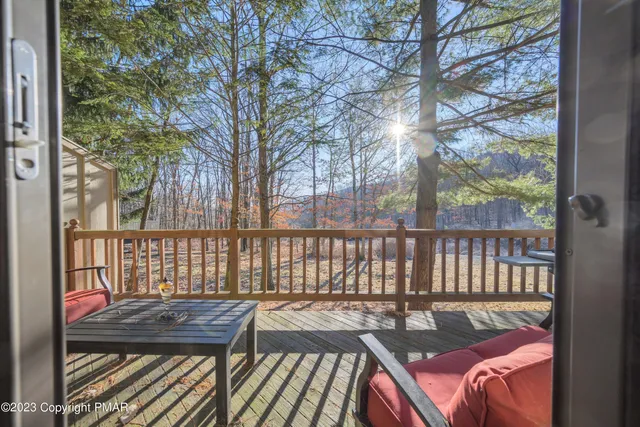 a view of a wooden chairs and bench in the balcony