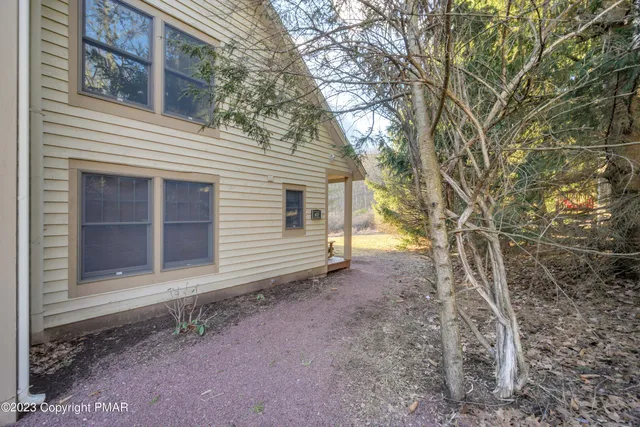 a view of a house with a yard and large tree