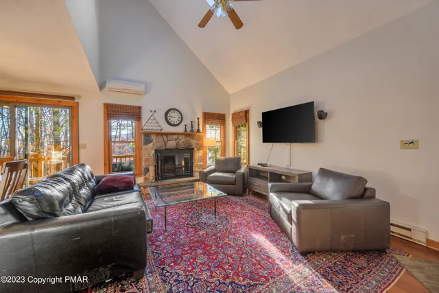 a living room with furniture a flat screen tv and a fireplace