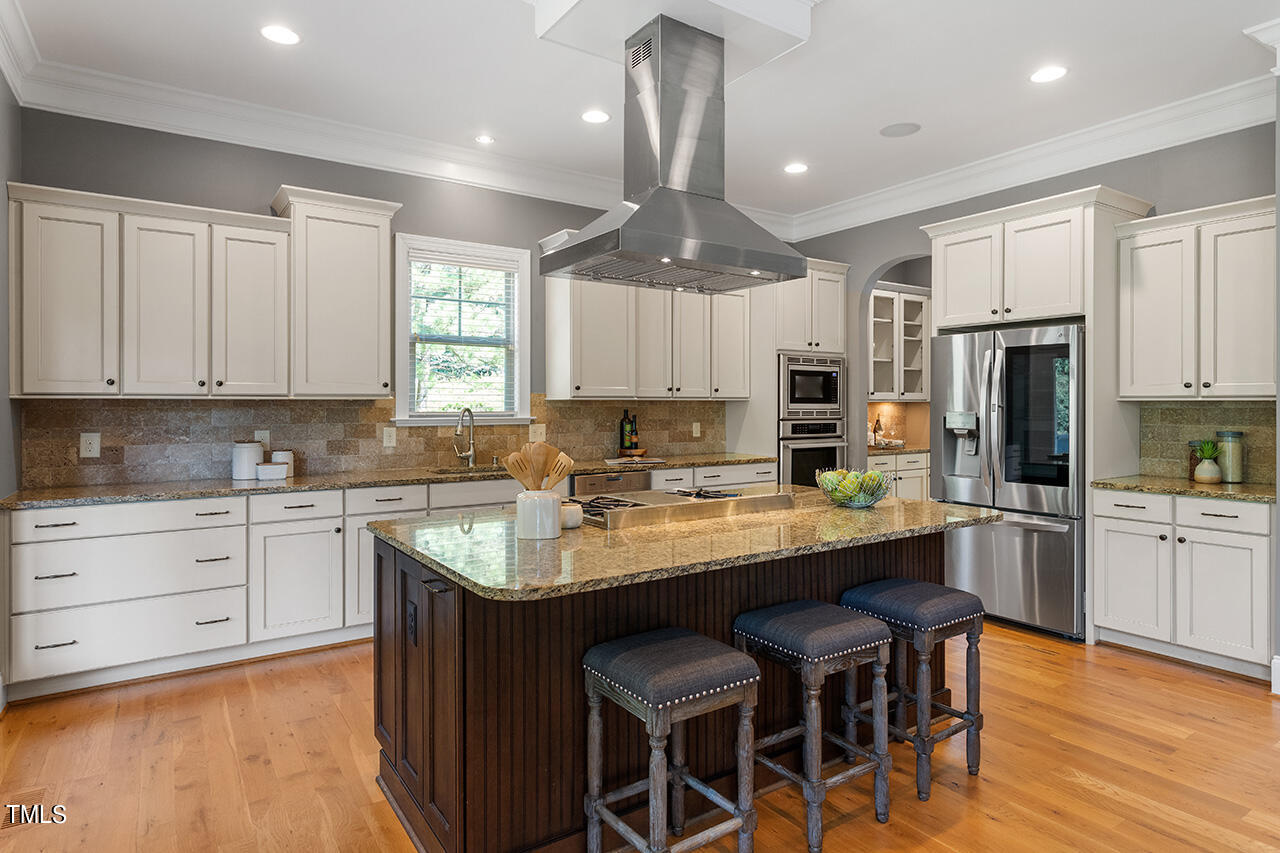 1036 Quiet Ridge Circle Raleigh, NC 27614 - Photo 13 of 60 a kitchen with kitchen island granite countertop wooden cabinets and refrigerator