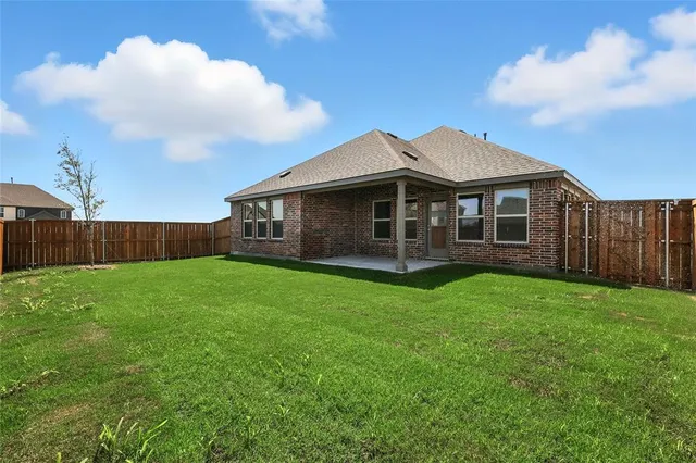 a view of a backyard with a bench and wooden fence