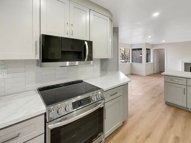 a view of empty room with wooden floor and stove