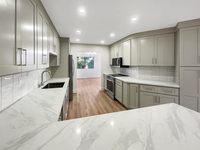 a kitchen with refrigerator cabinets and wooden floor