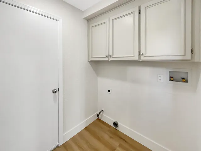 a view of an empty room with wooden floor and windows