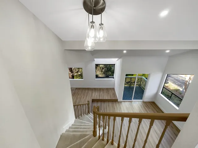 a view of a livingroom and kitchen with furniture wooden floor and a chandelier