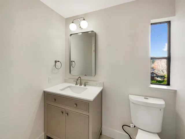 a bathroom with a toilet sink and mirror