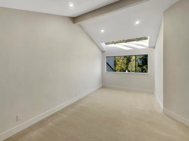 a view of a hallway with wooden floor and a kitchen view