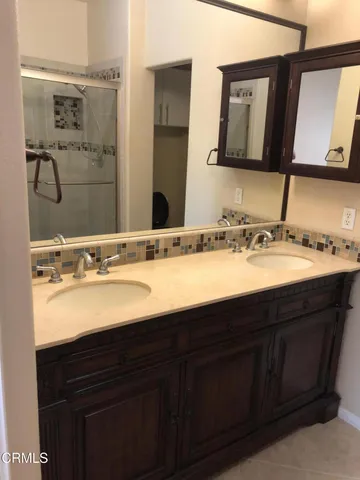 a bathroom with a double vanity sink and a mirror