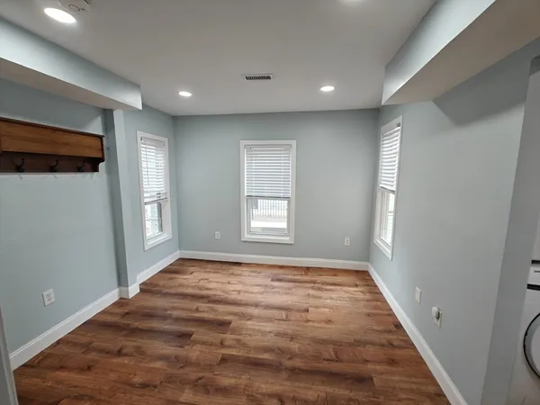 a view of empty room with wooden floor