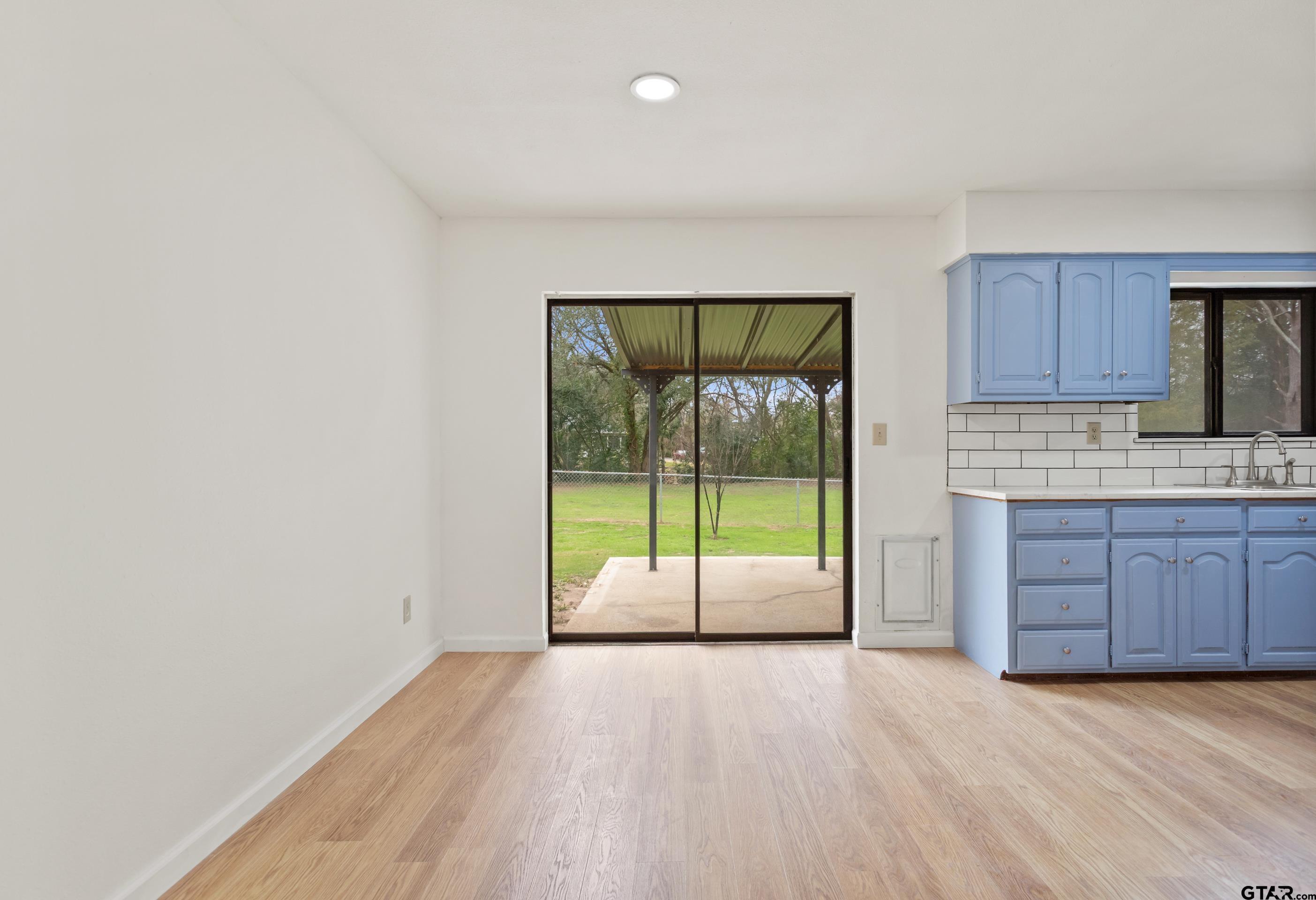 208 Treetop Lane Hideaway, TX 75771 - Photo 11 of 32 a view of a kitchen with a sink and dishwasher with wooden floor