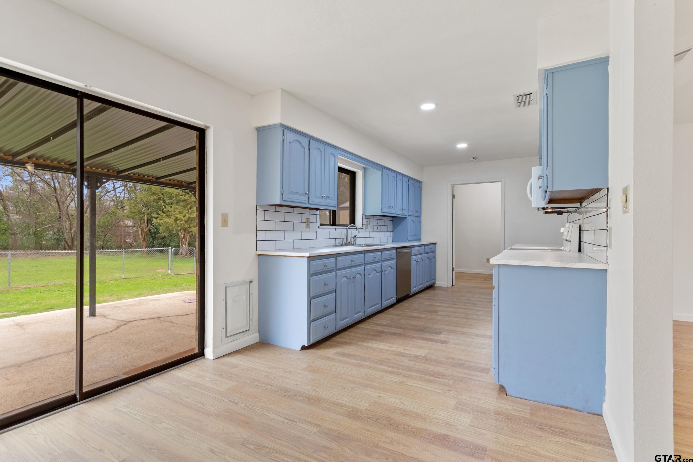 208 Treetop Lane Hideaway, TX 75771 - Photo 12 of 32 a large kitchen with a large window and stainless steel appliances
