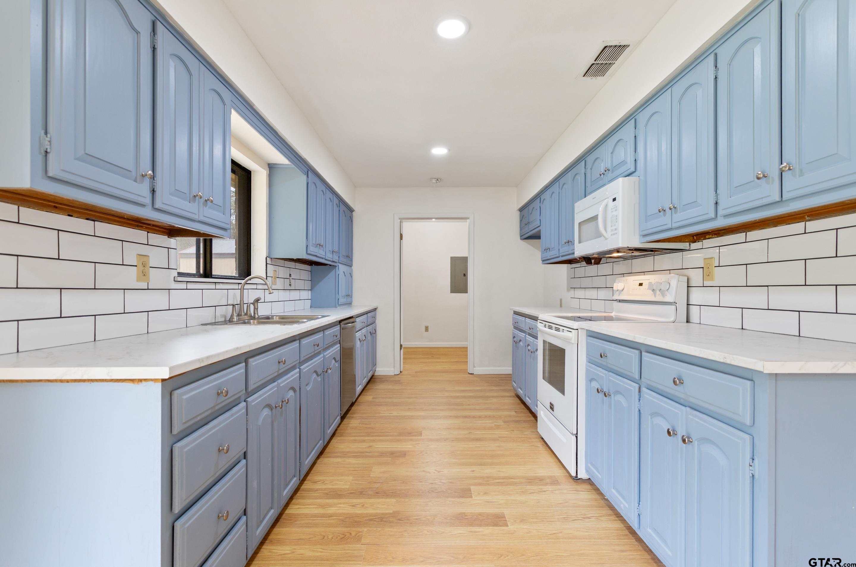 208 Treetop Lane Hideaway, TX 75771 - Photo 14 of 32 a large kitchen with stainless steel appliances granite countertop a sink and cabinets