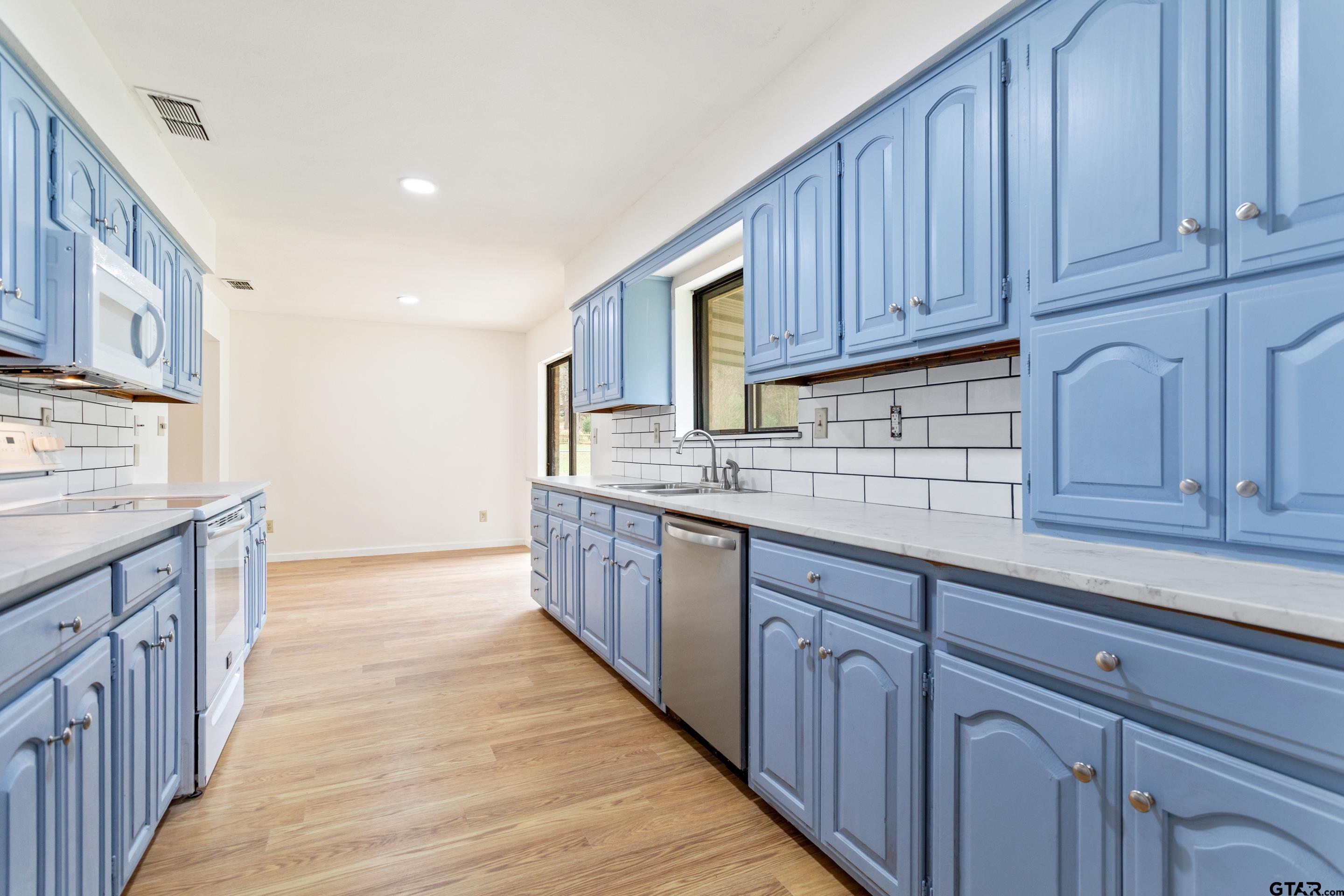 208 Treetop Lane Hideaway, TX 75771 - Photo 15 of 32 a kitchen with wooden cabinets and sink