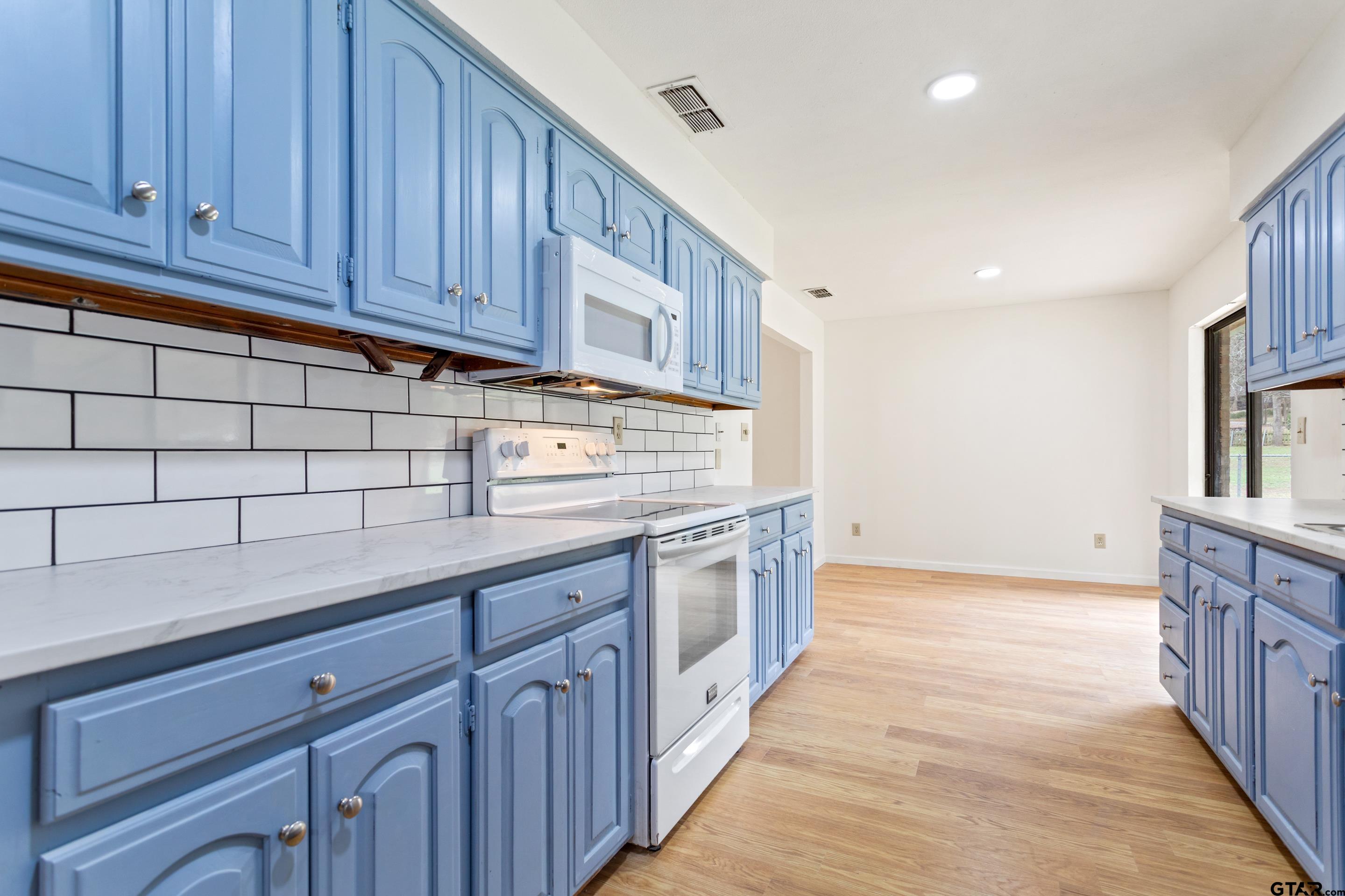 208 Treetop Lane Hideaway, TX 75771 - Photo 16 of 32 a kitchen with granite countertop wooden cabinets a sink and dishwasher