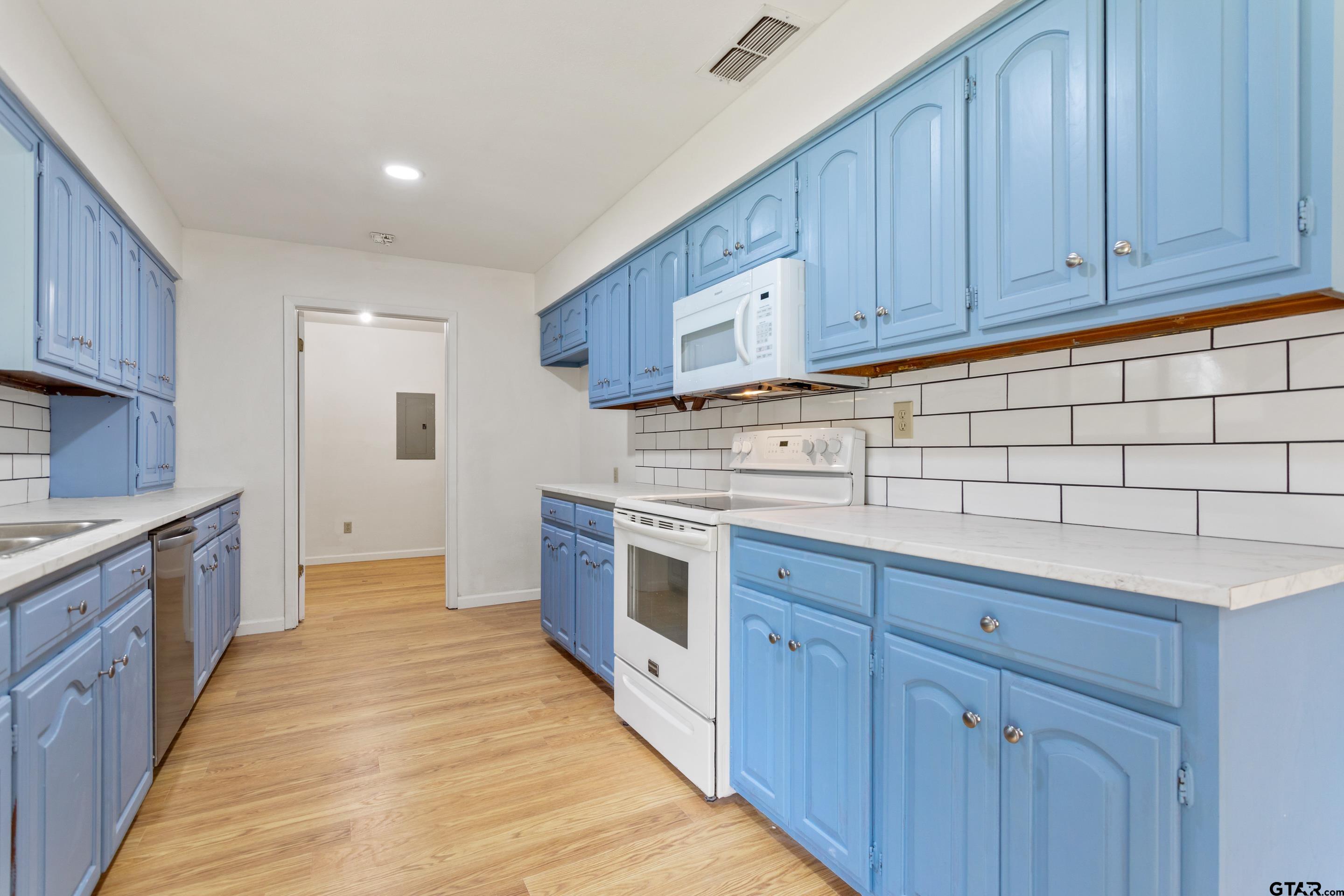 208 Treetop Lane Hideaway, TX 75771 - Photo 17 of 32 a kitchen with stainless steel appliances granite countertop a stove a sink and a refrigerator