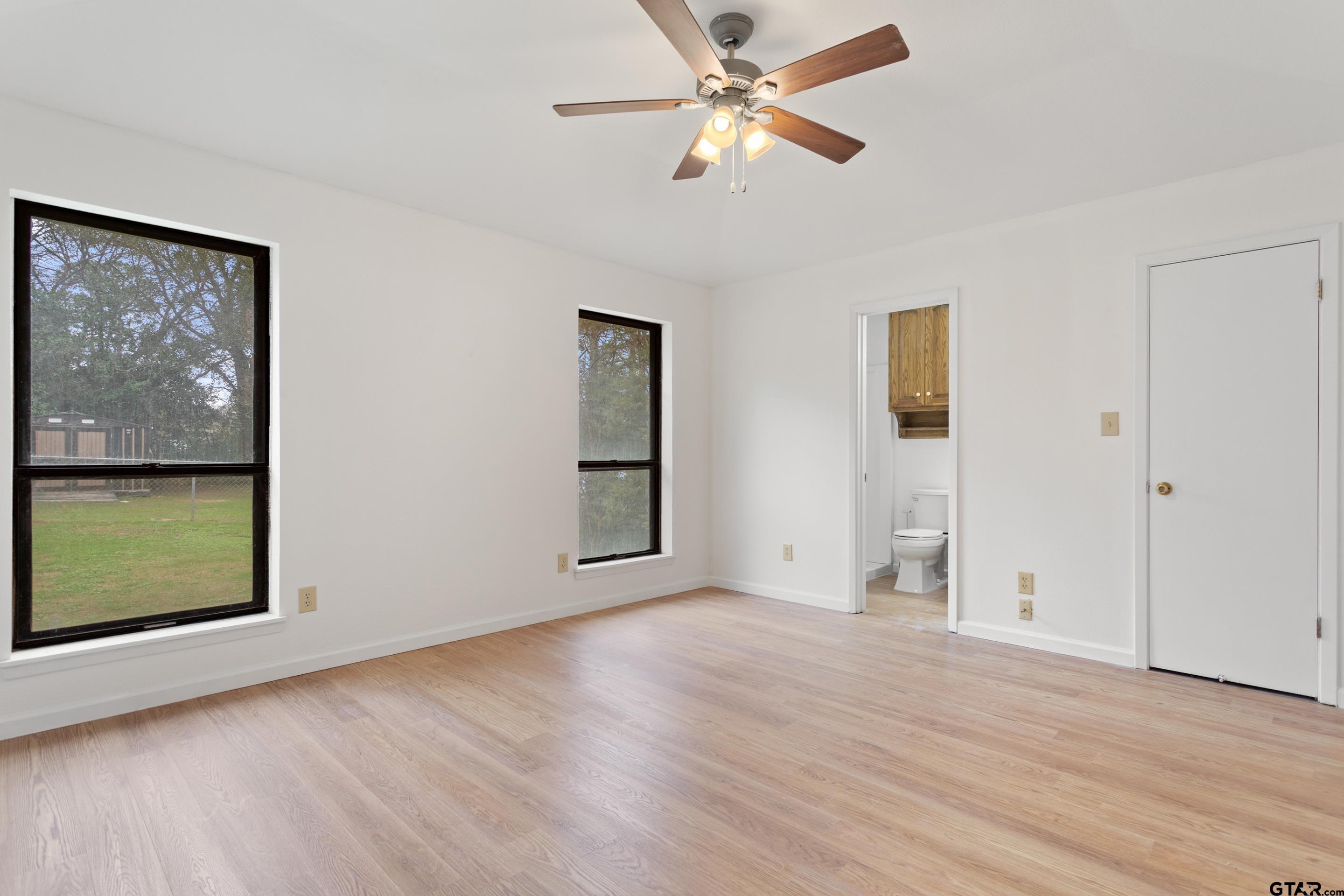 208 Treetop Lane Hideaway, TX 75771 - Photo 18 of 32 wooden floor in an empty room with a window