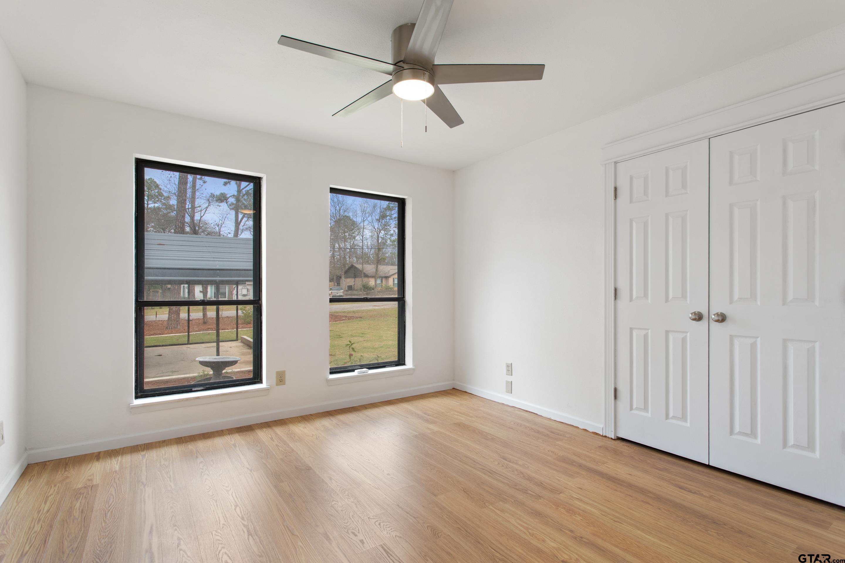 208 Treetop Lane Hideaway, TX 75771 - Photo 21 of 32 a view of an empty room with a window and wooden floor