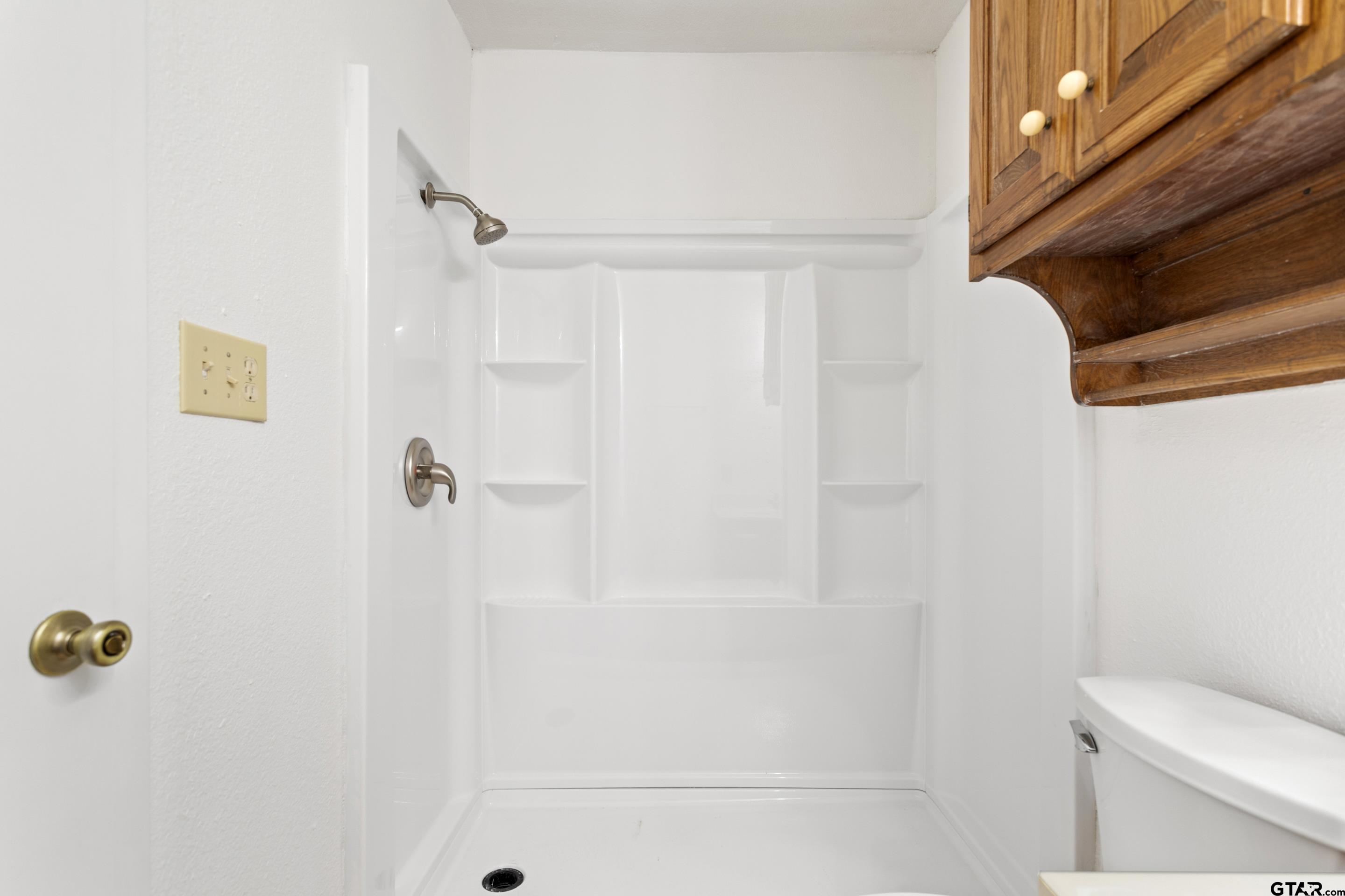 208 Treetop Lane Hideaway, TX 75771 - Photo 23 of 32 a bathroom with a shower and a toilet