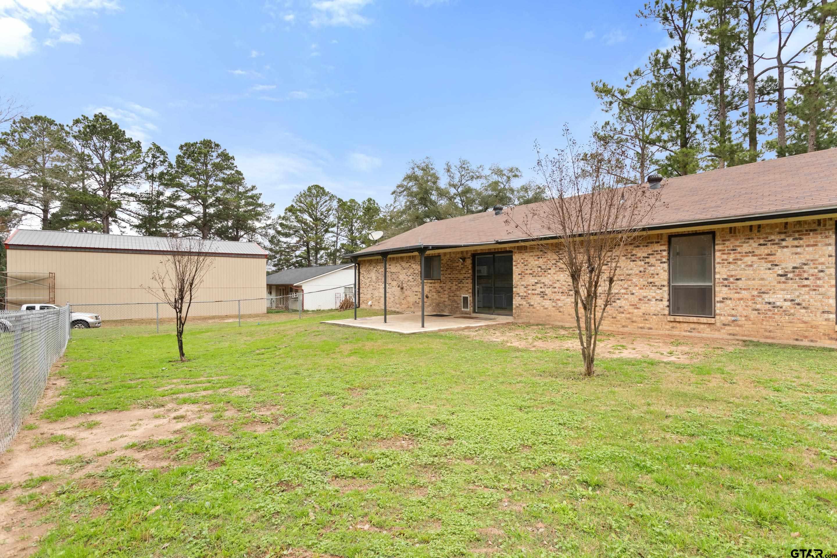 208 Treetop Lane Hideaway, TX 75771 - Photo 26 of 32 a house with huge green field in front of it