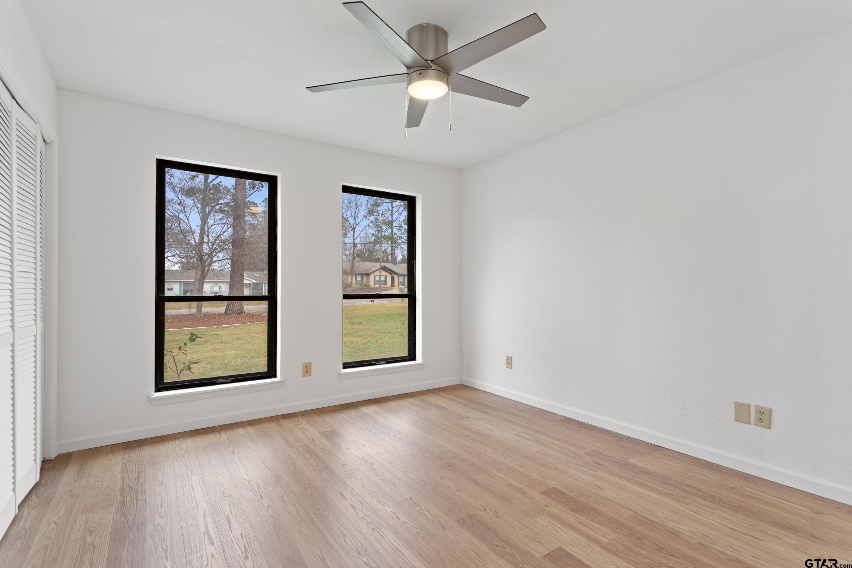 208 Treetop Lane Hideaway, TX 75771 - Photo 7 of 32 a view of an empty room with a window and wooden floor