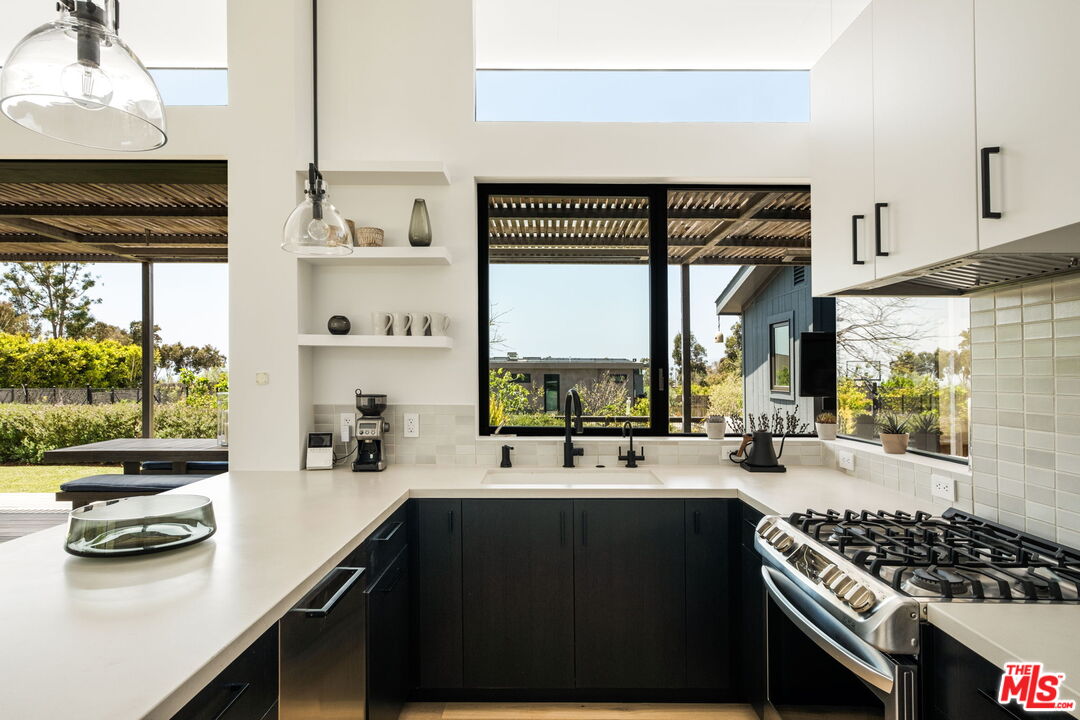 6755 Dume Drive, Unit GH Malibu, CA 90265 - Photo 18 of 31 a kitchen with stainless steel appliances a counter space and a window