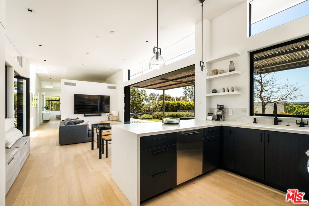 6755 Dume Drive, Unit GH Malibu, CA 90265 - Photo 19 of 31 a kitchen with a sink and living room view