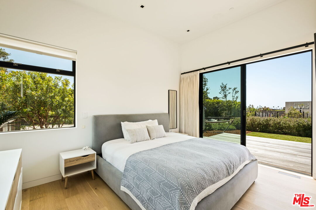 6755 Dume Drive, Unit GH Malibu, CA 90265 - Photo 20 of 31 a bedroom with a large window and a bed