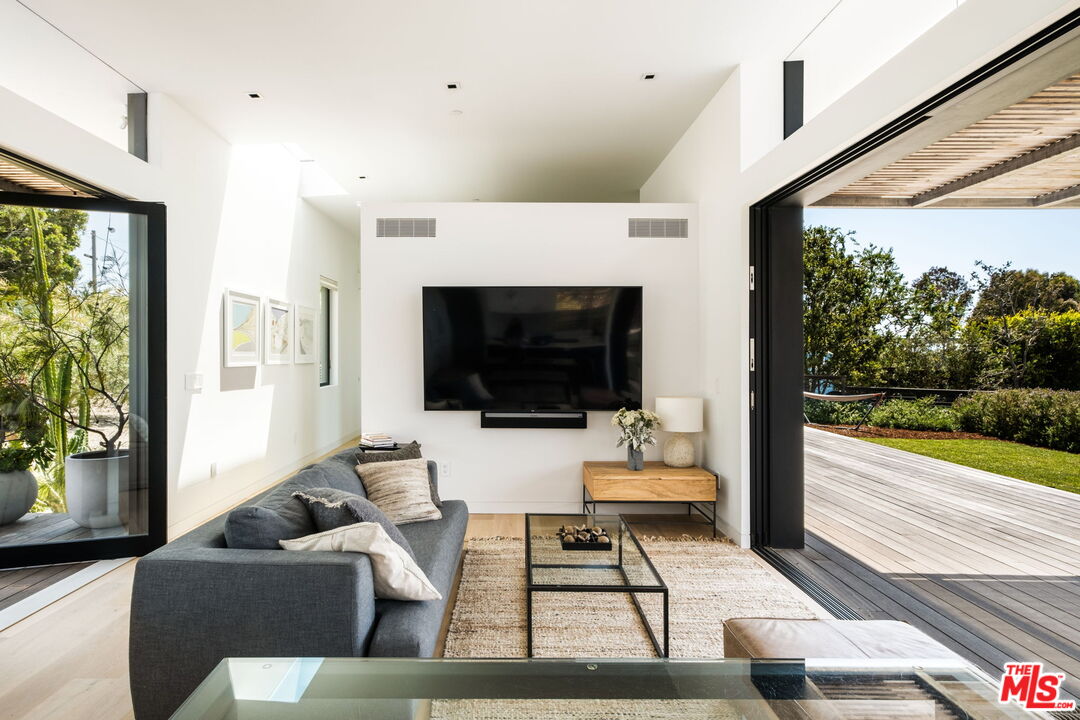 6755 Dume Drive, Unit GH Malibu, CA 90265 - Photo 6 of 31 a living room with furniture a flat screen tv and a fireplace