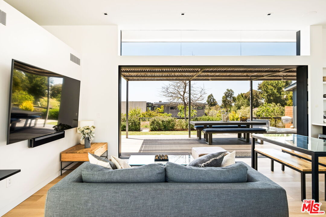 6755 Dume Drive, Unit GH Malibu, CA 90265 - Photo 7 of 31 a living room with couch a flat screen tv and floor to ceiling window