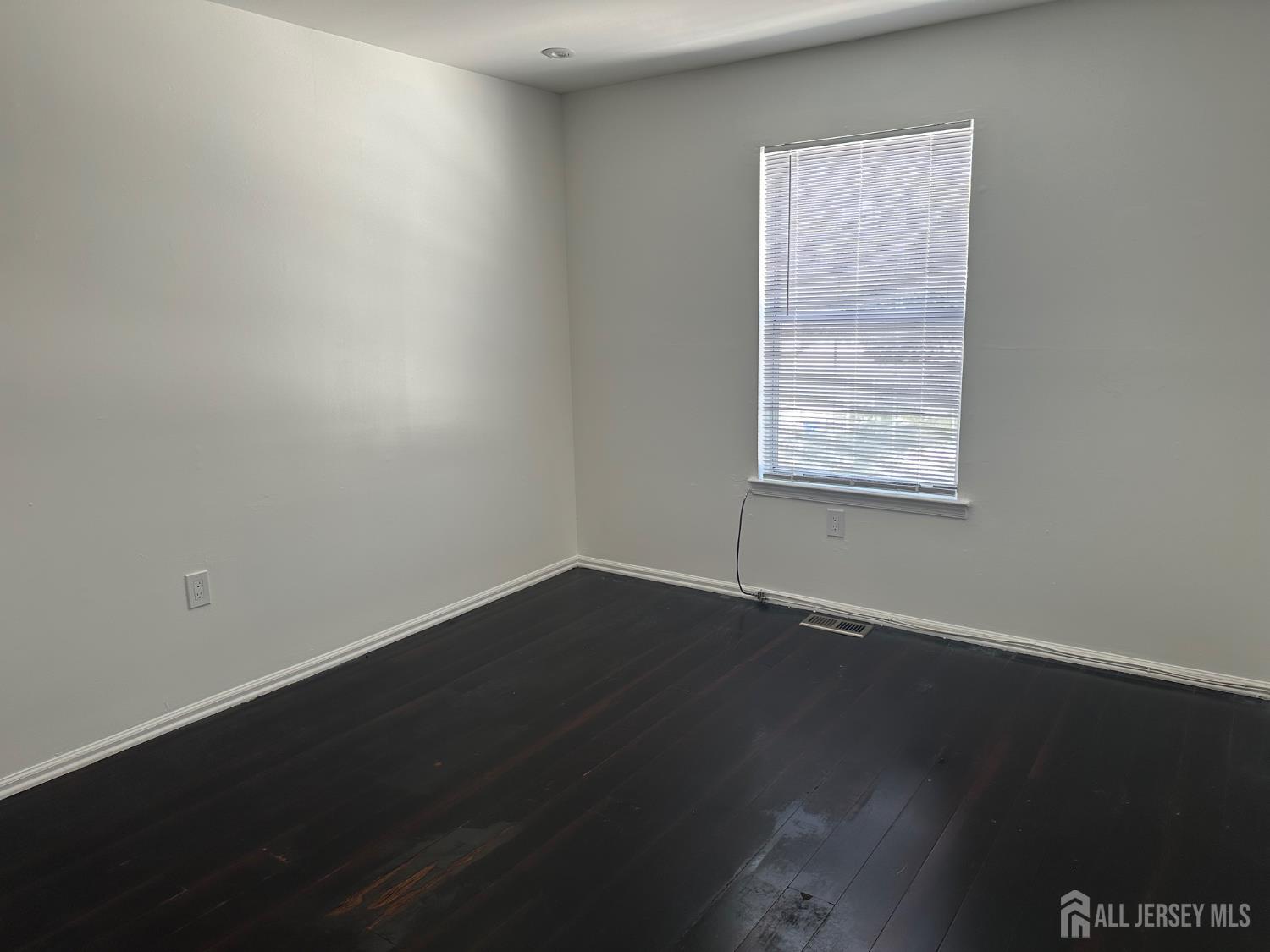 402 Rittenhouse Court North Brunswick, NJ 08902 - Photo 14 of 28 an empty room with wooden floor and windows