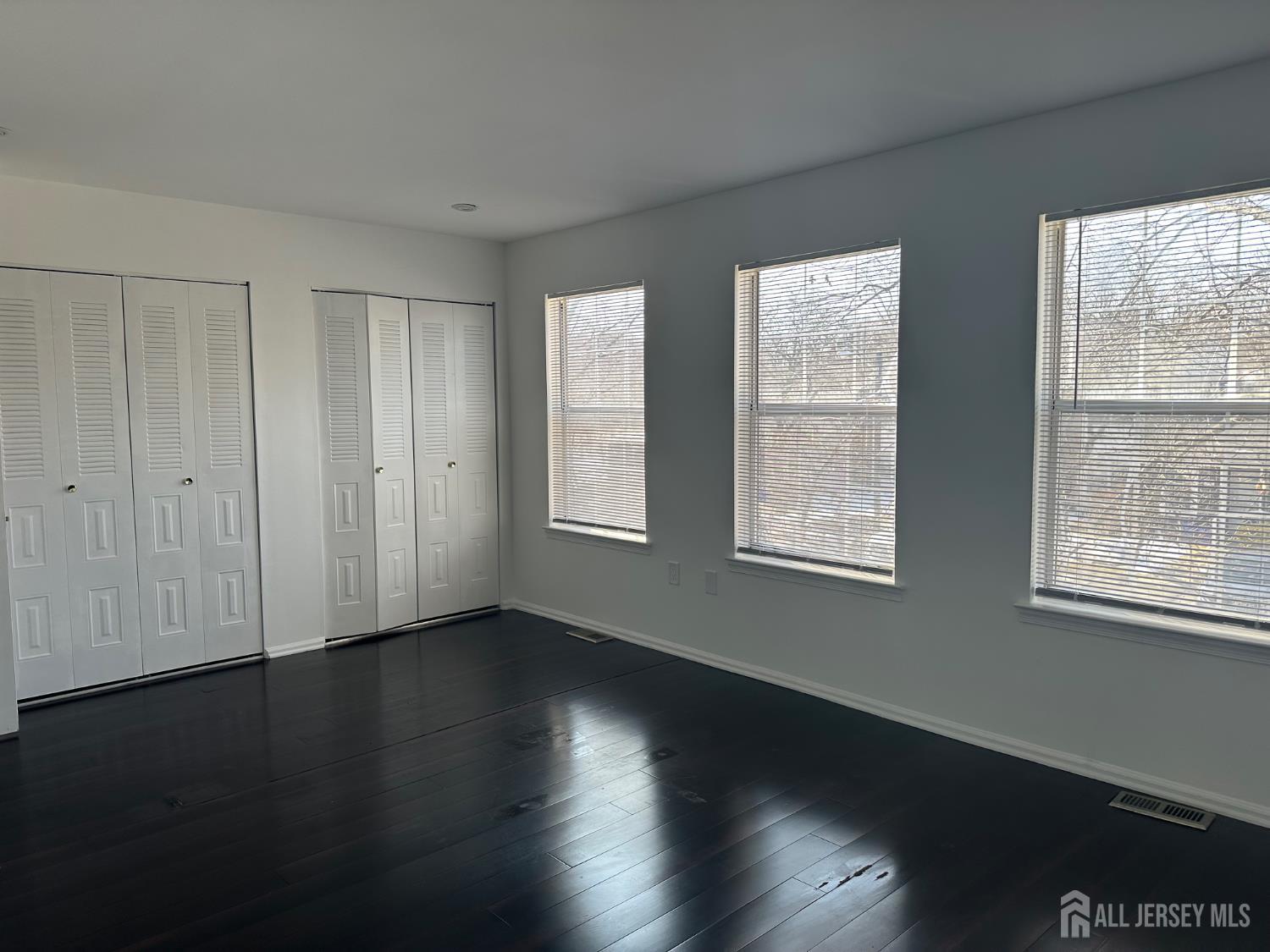402 Rittenhouse Court North Brunswick, NJ 08902 - Photo 22 of 28 a view of an empty room with wooden floor and a window