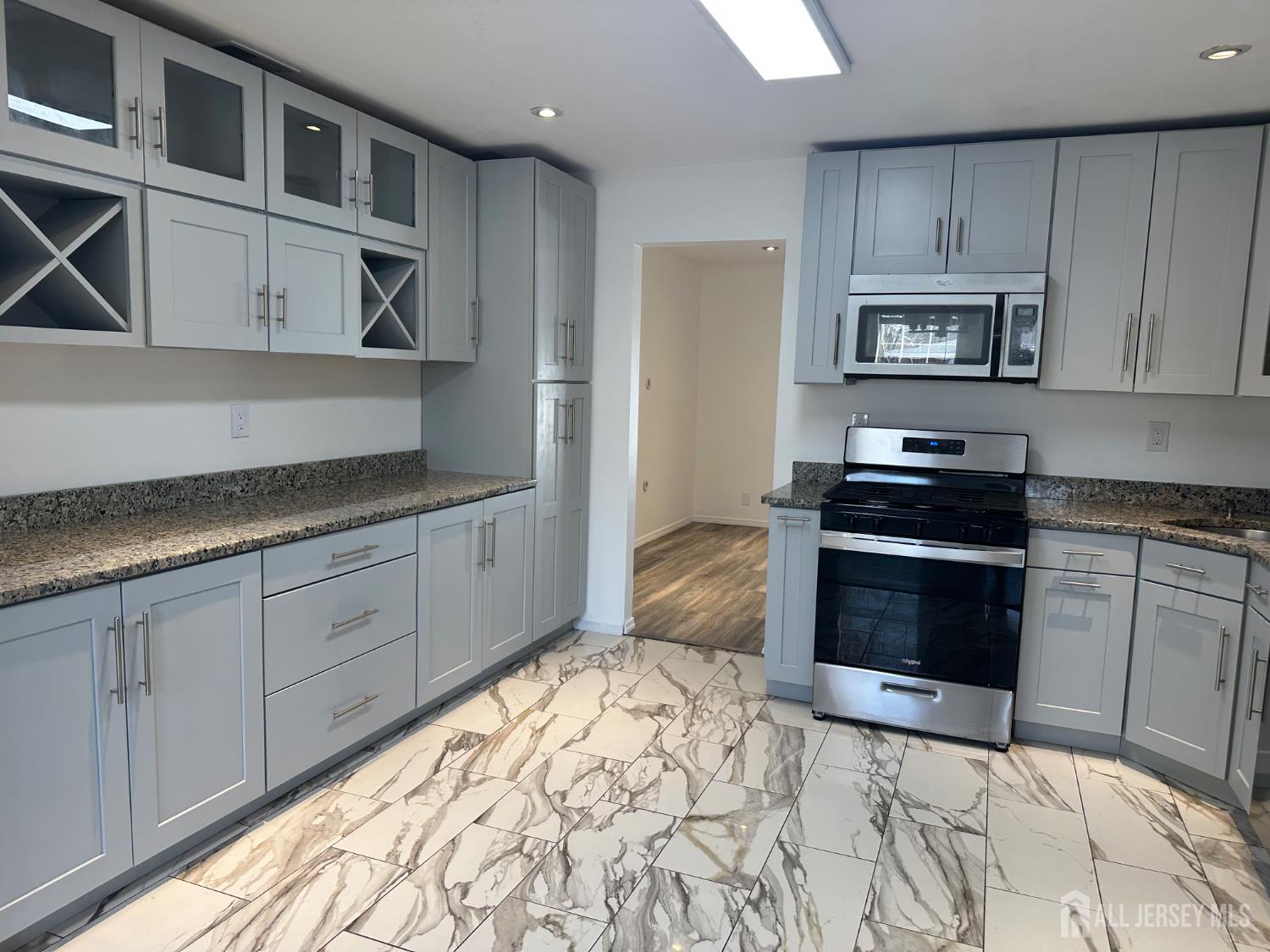 402 Rittenhouse Court North Brunswick, NJ 08902 - Photo 5 of 28 a kitchen with stainless steel appliances granite countertop a stove a sink and a microwave