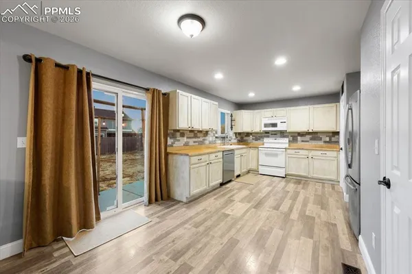 a kitchen with white cabinets and white appliances