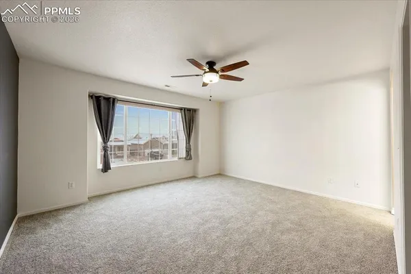 a view of an empty room with a ceiling fan
