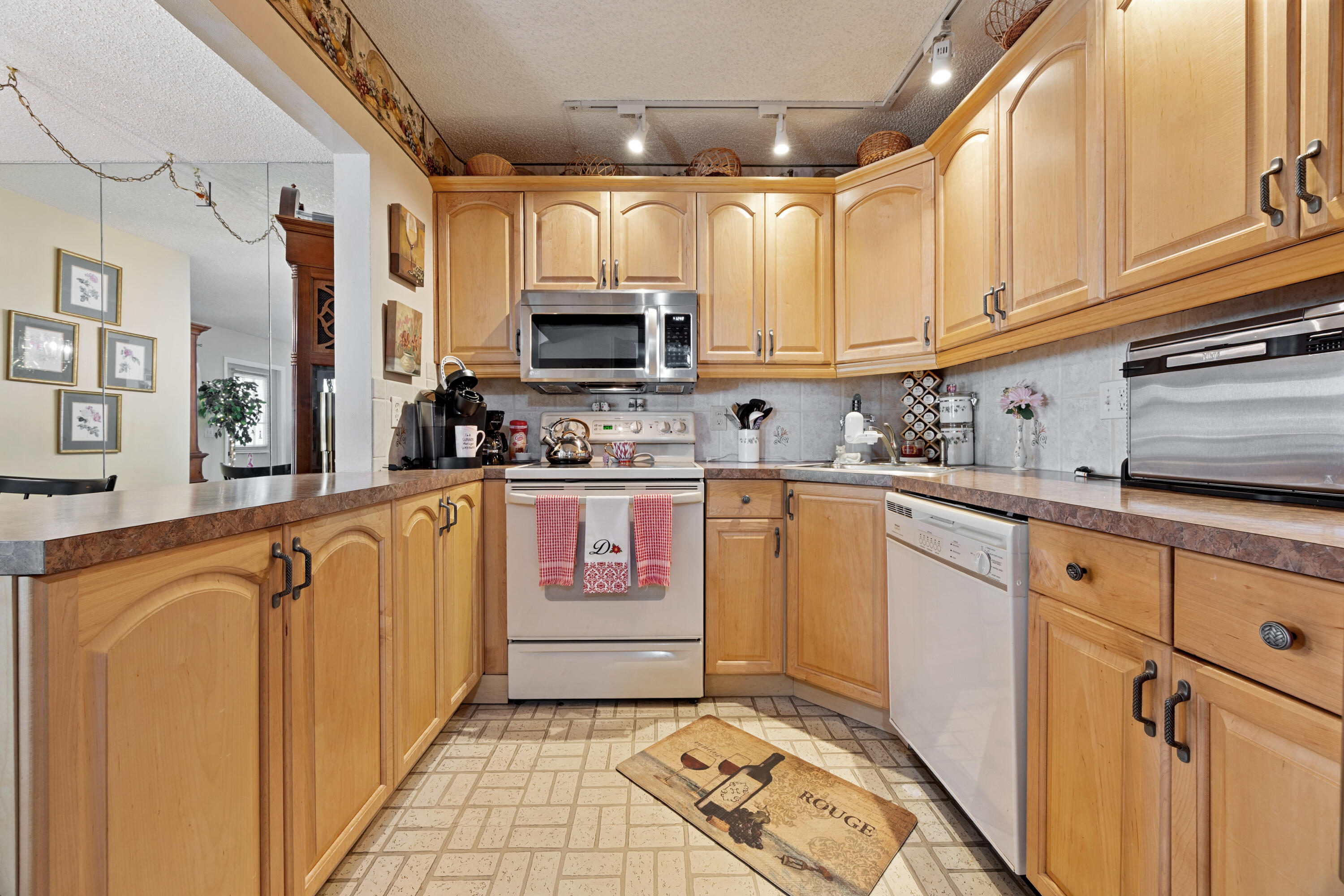 306 Pine Ridge Circle, Unit B2 Greenacres, FL 33463 - Photo 8 of 15 a kitchen with kitchen island granite countertop a sink stainless steel appliances and cabinets