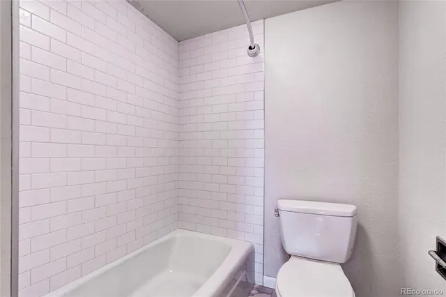 a bathroom with a toilet and bathtub