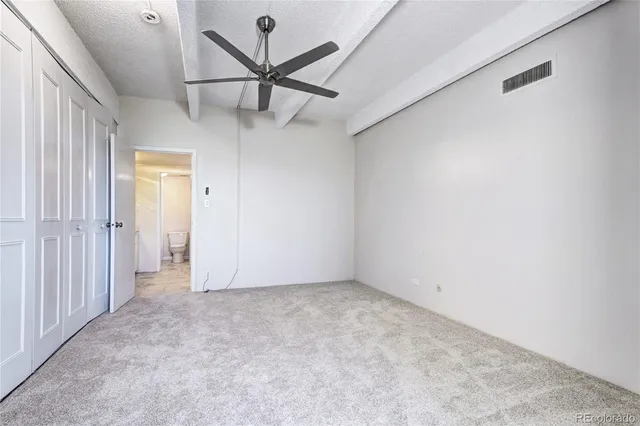 an empty room with a ceiling fan and a window
