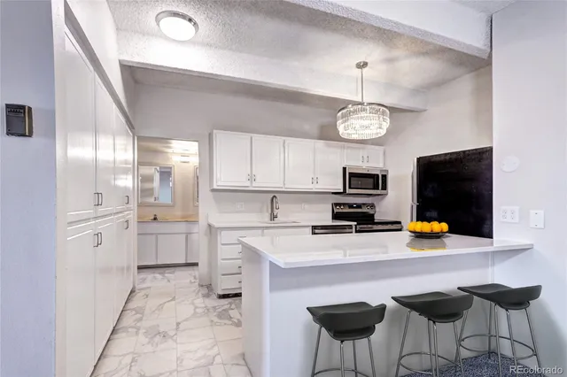 a kitchen with stainless steel appliances a stove a refrigerator and a microwave