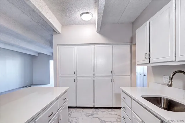 a kitchen with white cabinets and white appliances