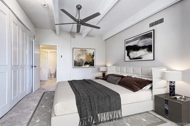 a bedroom with a large bed and a chandelier