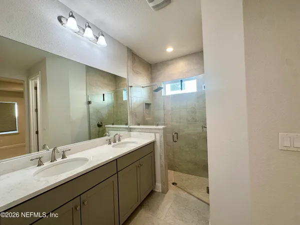 a bathroom with a double vanity sink mirror and double