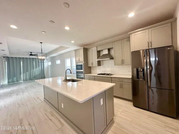 a kitchen with kitchen island a sink appliances and cabinets