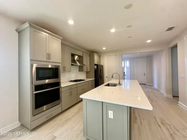 a kitchen with stainless steel appliances kitchen island granite countertop a stove a sink and a refrigerator
